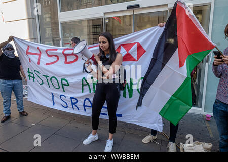 London, UK. 14th September 2019. Protesters outside the Oxford St branch of the HSBC Bank call on it to stop its support of military and technology companies that sell weapons and equipment to Israel to be used against Palestinians. HSBC has divested from Israel's largest private weapons company, but still owns shares in Caterpillar which supplies bulldozers to destroy Palestinian homes and construct illegal apartheid settlemetns. Credit: Peter Marshall/Alamy Live News Stock Photo