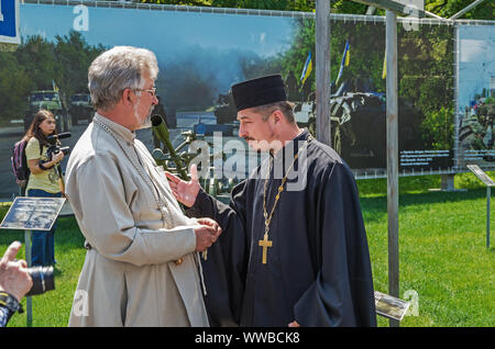 Dnipro, Ukraine - May 25, 2016: Ukrainian priests discussing problems of spirituality and faith on the opening day of museum Russian-Ukrainian war in Stock Photo