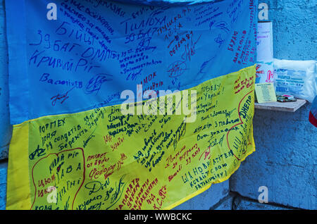 Dnipro, Ukraine - May 25, 2016: Ukrainian flag with signatures of soldiers located in exact copy of a military  in museum of the Russian-Ukrainian war Stock Photo