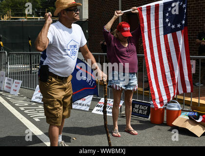 Dahlonega, Georgia, USA. 14th Sep, 2019. A woman holds an American flag as she says the Pledge of Allegiance during a rally organized by longtime white nationalist leader Chester Doles in Dahlonega, Georgia on Saturday. Doles billed the event as an 'American Patriot Rally'' to honor Trump and many of those who attended bore swastika tattoos and other symbols of white supremacy. Hundreds of law enforcement officers outnumbered the rally participants and counter protesters. Credit: Miguel Juarez Lugo/ZUMA Wire/Alamy Live News Stock Photo