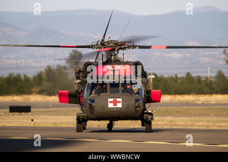 A U.S. Army UH-60 Black Hawk helicopter from the Mather Army Aviation Support Facility lands at Redding Municipal Airport, Sept. 8, 2019, in Redding, California, while supporting the Red Bank Fire burning in Tehama County. Six Cal Guard helicopters were activated to assist state and federal agencies battling a pair of wildfires in the county. (U.S. Air National Guard photo by Staff Sgt. Crystal Housman) Stock Photo