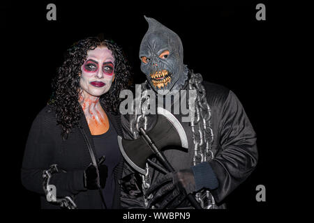 Salem Massachusetts USA 10/31/2015. Man and woman face makeup and mask on a dark halloween night. Editorial use only Stock Photo