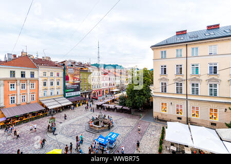 Lviv, Ukraine - July 30, 2018: Aerial high angle view on Market square in Old town with people walking by colorful architecture, Neptune water fountai Stock Photo