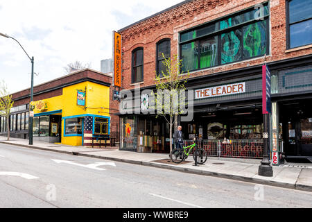 Asheville, USA - April 19, 2018: People walking on Patton avenue by farm burger restaurant and Mexican food cafe with stores shops and multicolored hi Stock Photo