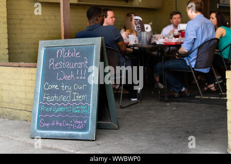 Mobile, USA - April 21, 2018: Old town Dauphin street sign in Alabama famous southern town, city with restaurant week placard for seafood Stock Photo