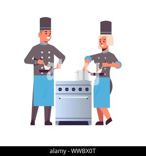 cooks couple professional chefs using frying pan stirring food man woman restaurant kitchen workers in uniform standing together near stove cooking Stock Vector