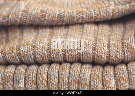 Mottled beige knitted woollen sweater. Texture detail close up. Stock Photo