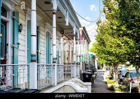 New Orleans, USA - April 22, 2018: Blue and white pastel color row houses of traditional architecture in Louisiana city on street sidewalk at French Q Stock Photo