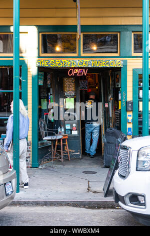 New Orleans, USA - April 22, 2018: Frenchmen street in Louisiana old building entrance sign to famous Spotted Cat Music Club, people walking on street Stock Photo
