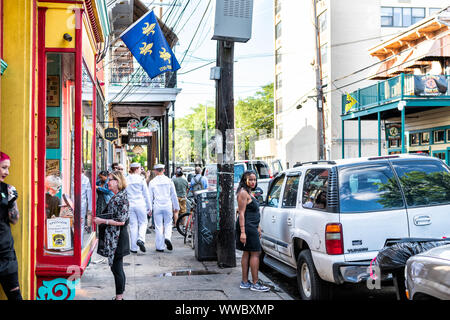 New Orleans, USA - April 22, 2018: Frenchmen street in Louisiana old town city with people, sailors walking by bars, restaurants and pubs cafe Stock Photo