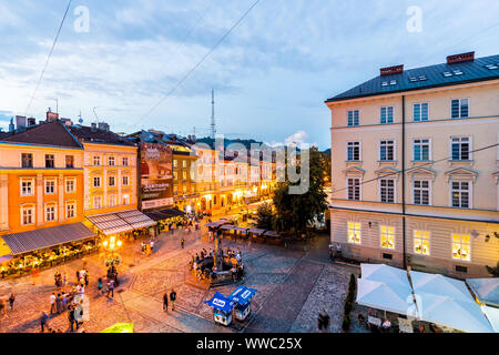 Lviv, Ukraine - July 30, 2018: Aerial view on Old town market square, people by colorful architecture, Neptune fountain and restaurants in summer with Stock Photo