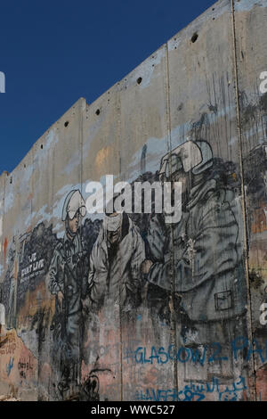 A large graffito shows Israeli soldiers arresting a blindfolded Palestinian man on the separation barrier or wall in Aida also spelled 'Ayda, a Palestinian refugee camp situated 2 kilometers north of Bethlehem in the central West Bank established in 1950 by refugees from the Jerusalem and Hebron areas. Palestinian Territories, Israel Stock Photo