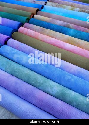 Rolls of colorful fabrics. Dyed fabric for sewing. Cross stitch fabric Stock Photo
