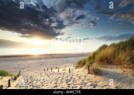 sunset sunshine over sand path to North sea beach, Holland Stock Photo