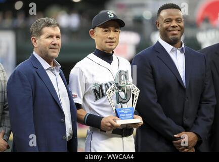 New York Yankees pitcher Mariano Rivera, left, waves to the crowd after  accepting a check for the Mariano Rivera Foundation from Seattle Mariners'  former designated hitter Edgar Martinez, right, prior to a