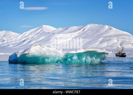 Blue ice iceberg, formed when a glacier calves, floating in the arctic waters of Svalbard, a Norwegian archipelago between mainland Norway and the Nor Stock Photo