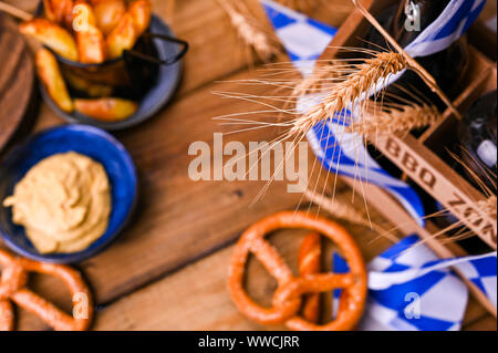 German sausages on the grill. Traditional and pastry brezel for the beer festival. Wood background and decor. View from above Stock Photo