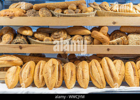 Modern bakery shop with assortment of bread on shelf, close up. Food concept. Variety of baked products at bread shop Stock Photo
