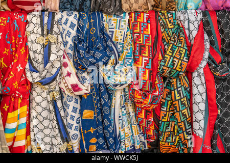 Rows of colourful silk scarfs hanging at a street market stall in Bodrum, Turkey. Close up Stock Photo