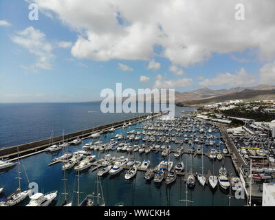 Aerial photo of the beautiful Boats and Boat Harbour Marina and pier taken in Lanzarote in Spain one of the Canary islands, showing all kinds of saili Stock Photo