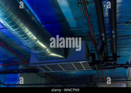 HVAC Duct Cleaning, Ventilation pipes in silver insulation material hanging from the ceiling inside new building. High resolution image gallery. Stock Photo