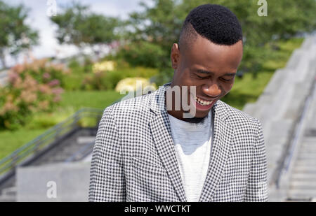 Cheerful Afro American looking down with laughter Stock Photo