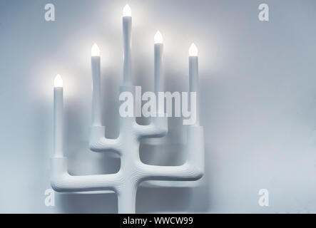 White lamp in the form of a candlestick for five candles. Stock Photo