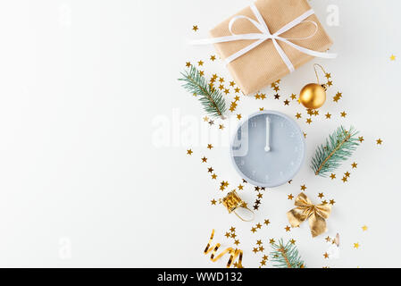 Christmas decorations. Composition with alarm clock, gift box and golden festive confetti on white background. Flat lay christmas background with copy Stock Photo