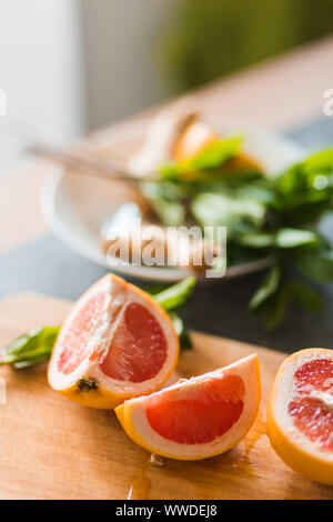 Closeup of ripe citrus pieces on wooden Board. Red grapefruit, lime, lemon on the kitchen table with mint. Healthy food, vitamins, summer concept Stock Photo