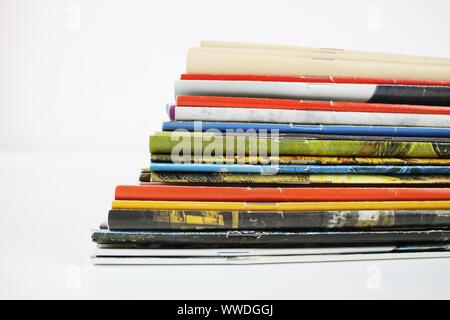 A stack of colored magazines on a white background, vertical end spine. Stock Photo