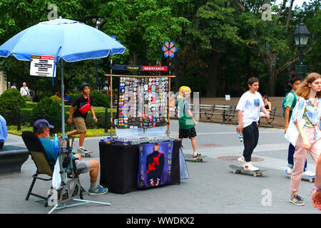 Man selling Resistance and anti-Trump buttons, fridge magnets, and stickers in Washington Square Park in Manhattan on JULY 26th, 2019 in New York, USA Stock Photo