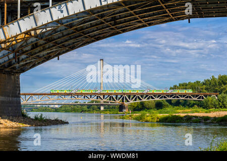 Bridges on Vistula River in city of Warsaw in Poland, view from under Poniatowski Bridge to rail Srednicowy Bridge with train and Swietokrzyski in the Stock Photo