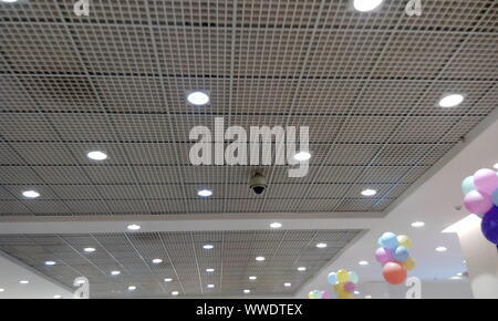 Perforated Grid ceiling and White Painted gypsum ceiling joints for an Retail shop during festival sale and decorated by hanging balloons Stock Photo