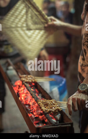 Chicken satay grill at a busy street food market Stock Photo