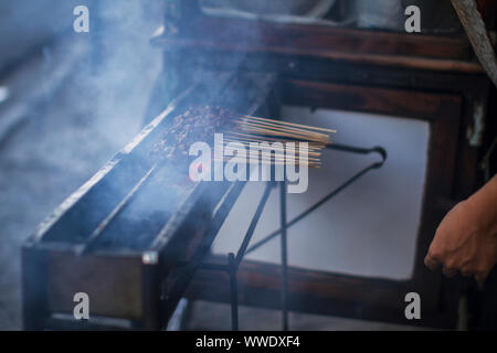 Chicken satay grill at a busy street food market Stock Photo