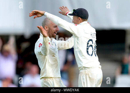 England's Jack Leach (left) celebrates with team mate Joe Root after taking the wicket of Australia's Josh Hazlewood to secure victory during day four of the fifth test match at The Kia Oval, London. Stock Photo