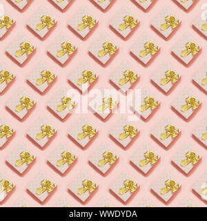 Pink gift boxes with golden ribbon on pastel pink surface. Top view. Seamless pattern. Flat lay style. Celebration anniversary background. Stock Photo