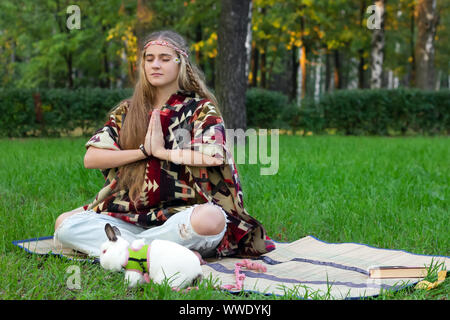 hippie girl meditation yoga in the park  vintage rabbit pet Stock Photo