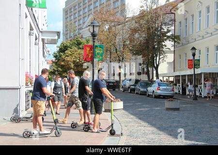 Men driving on electric scooters rented for minutes from the 'Samokato' company by the Soviet street - main pedestrian city street are seen in Grodno, Belarus on 30 August 2019  © Michal Fludra / Alamy Live News Stock Photo