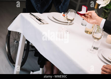 cropped view of man making wedding proposal to disabled girlfriend during romantic dinner Stock Photo