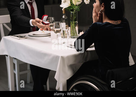 cropped view of young man making wedding proposal to disabled girlfriend while having romantic dinner Stock Photo