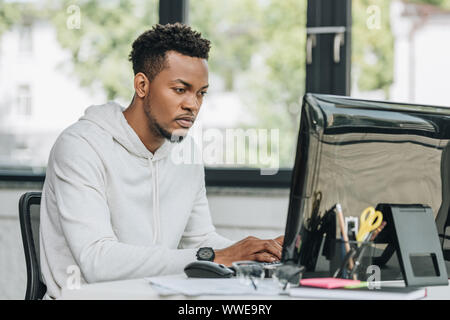 concentrated african american programmer working on computer in office Stock Photo