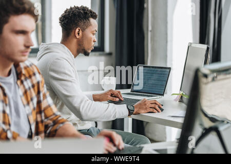 selective focus of two multicultural programmers working together in office Stock Photo