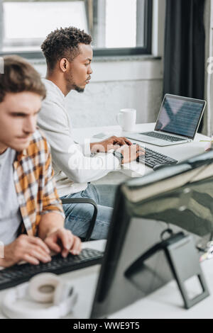 selective focus of two young multicultural programmers working together in office Stock Photo