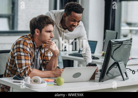 two serious multicultural programmers working in office together Stock Photo