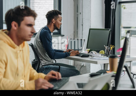 selective focus of two young multicultural programmers working in office together Stock Photo