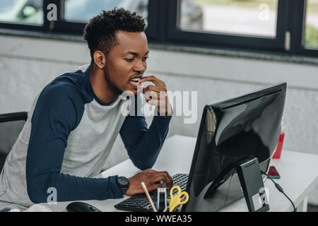 concentrated african american programmer working on computer in office Stock Photo