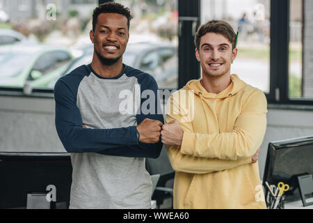 two happy multicultural programmers smiling at camera in office Stock Photo