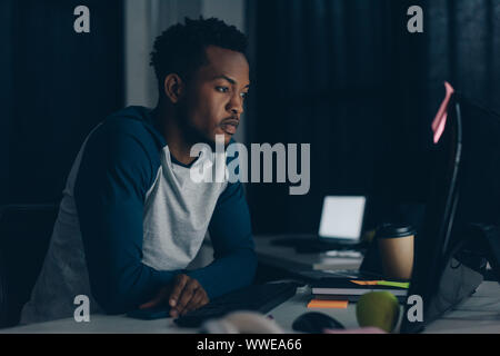 thoughtful african american programmer working at night in office Stock Photo