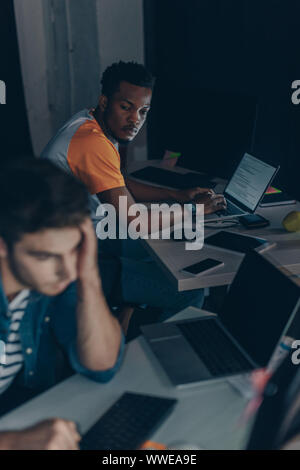 two young multicultural programmers working at night in office Stock Photo